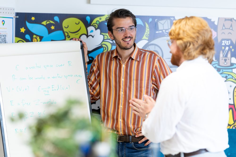 Founder Emilio Garcia Padron explaining a mathematical model on a whiteboard